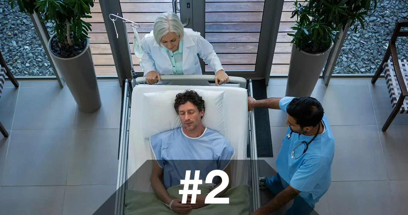 Image of patient lying on a bed surrounded by doctors and nurses